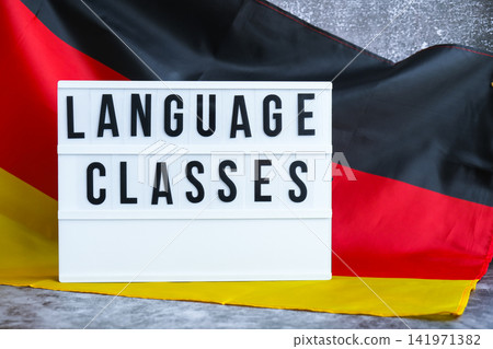 Lightbox with text LANGUAGE CLASSES National symbol of Germany. German wave silky flag background. Education and learning Lightbox with text LANGUAGE CLASSES National symbol of Germany. German wave silky flag background. Education and learning 141971382
