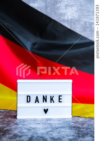 Lightbox with text DANKE THANK YOU National symbol of Germany. German wave silky flag background. thanksgiving day and gratitude Lightbox with text DANKE THANK YOU National symbol of Germany. German wave silky flag background. thanksgiving day and gratitude 141971393