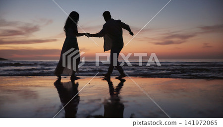 Couple, walking and holding hands at beach for travel, journey and romantic date on holiday. Silhouette, sunset or people at seashore with space, connection or tropical vacation for adventure getaway Couple, walking and holding hands at beach for travel, journey and romantic date on holiday. Silhouette, sunset or people at seashore with space, connection or tropical vacation for adventure getaway 141972065