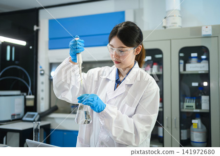 Young Asian Female Scientist Using Pipette and Erlenmeyer Flask in Modern Research Laboratory Young Asian Female Scientist Using Pipette and Erlenmeyer Flask in Modern Research Laboratory 141972680