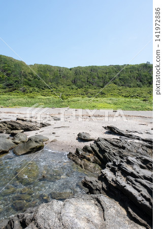 城島海岸的岩石海岸,湛藍的天空和無邊無際的綠色草地。 城島海岸的岩石海岸,湛藍的天空和無邊無際的綠色草地。 141972886