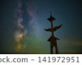 Milky Way Galaxy and Shooting Stars over Ornate Wooden Wayside Cross with Angel Wings under Night Sky 141972951