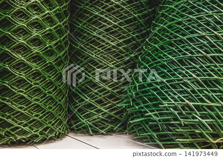 Green plastic mesh roll close up garden used protection fencing object material Green plastic mesh roll close up garden used protection fencing object material 141973449
