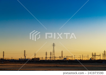 夕陽西下,金色的光芒映襯著輸電塔的輪廓。 夕陽西下,金色的光芒映襯著輸電塔的輪廓。 141973590
