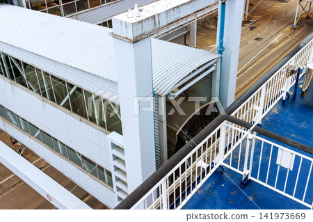 Covered passenger boarding gangway at ferry terminal in harbour Covered passenger boarding gangway at ferry terminal in harbour 141973669