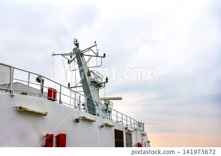 Passenger ferry mast with radar, communication antennas and marine equipment under cloudy sunset sky. Passenger ferry mast with radar, communication antennas and marine equipment under cloudy sunset sky. 141973672