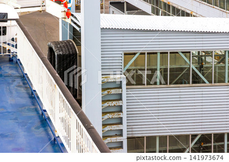 Covered passenger boarding gangway at ferry terminal in port Covered passenger boarding gangway at ferry terminal in port 141973674