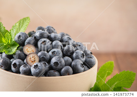 Fresh ripe blueberries with mint leaves in ceramic bowl Fresh ripe blueberries with mint leaves in ceramic bowl 141973774
