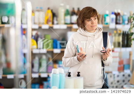 Store visitor woman purchases in household chemicals department, choose eye shadow pallet Store visitor woman purchases in household chemicals department, choose eye shadow pallet 141974029