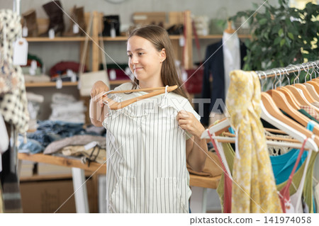 teenager chooses summer clothes in a store 141974058
