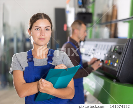 Portrait of foreman girl with folder of documents in glass workshop 141974152