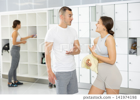 Young man and woman talking in locker room Young man and woman talking in locker room 141974198