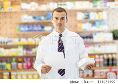Male pharmacist with medical prescription in hands. Male pharmacist with medical prescription in hands. 141974199