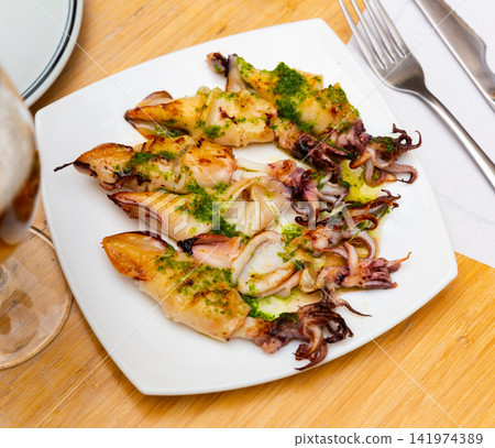 Traditional asian dish is barbecue squid,drizzled with spinach sauce. 141974389
