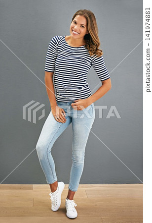 Fashion, smile and portrait of woman on a wall isolated on a gray background, backdrop or space. Confidence, style and happy model in casual clothes, jeans and young student in shirt in Australia Fashion, smile and portrait of woman on a wall isolated on a gray background, backdrop or space. Confidence, style and happy model in casual clothes, jeans and young student in shirt in Australia 141974881