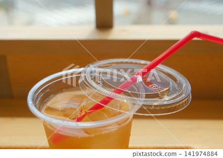 A clear cup and tea with ice. A clear cup and tea with ice. 141974884