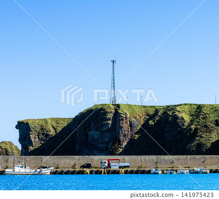 Cape Ochishi as seen from Ochishi Fishing Port in Nemuro City, Hokkaido, on a clear day. Cape Ochishi as seen from Ochishi Fishing Port in Nemuro City, Hokkaido, on a clear day. 141975423