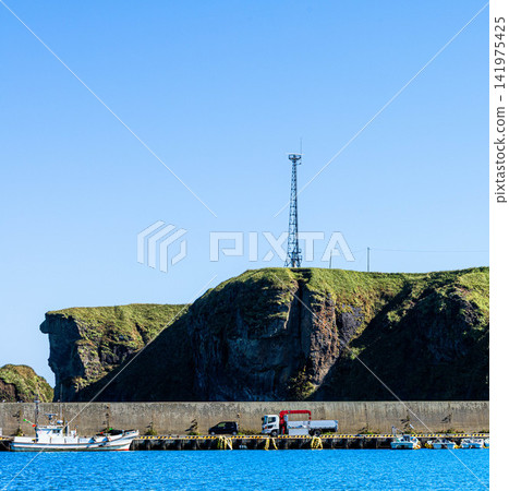 Cape Ochishi as seen from Ochishi Fishing Port in Nemuro City, Hokkaido, on a clear day. Cape Ochishi as seen from Ochishi Fishing Port in Nemuro City, Hokkaido, on a clear day. 141975425