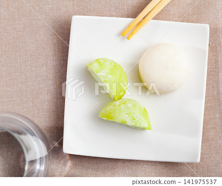 Mochi ice cream and wooden sticks on japanese plate closeup Mochi ice cream and wooden sticks on japanese plate closeup 141975537