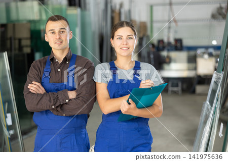 Portrait of two positive glaziers with folder of documents in glass workshop Portrait of two positive glaziers with folder of documents in glass workshop 141975636