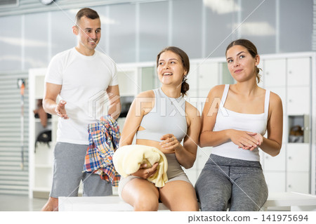 Young man intervenes in conversation between two girls in dressing room. Young man intervenes in conversation between two girls in dressing room. 141975694