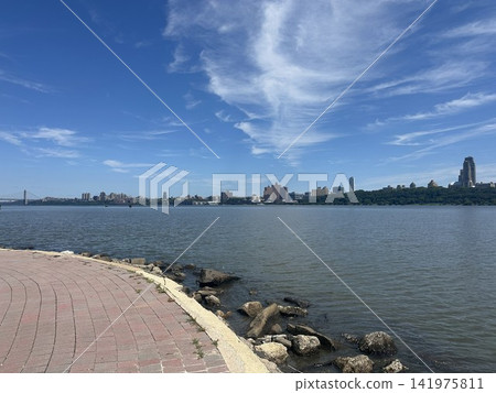 A view of the New York cityscape and blue sky from the promenade along the Hudson River. A view of the New York cityscape and blue sky from the promenade along the Hudson River. 141975811