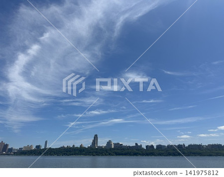 Summer blue skies and white clouds stretching over the Hudson River and the Manhattan skyline. Summer blue skies and white clouds stretching over the Hudson River and the Manhattan skyline. 141975812