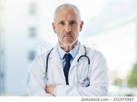 Doctor, serious and portrait of mature man in a hospital at a cardiology clinic with arms crossed. Professional, medical employee and stethoscope with healthcare, wellness and cardiologist consultant Doctor, serious and portrait of mature man in a hospital at a cardiology clinic with arms crossed. Professional, medical employee and stethoscope with healthcare, wellness and cardiologist consultant 141975987