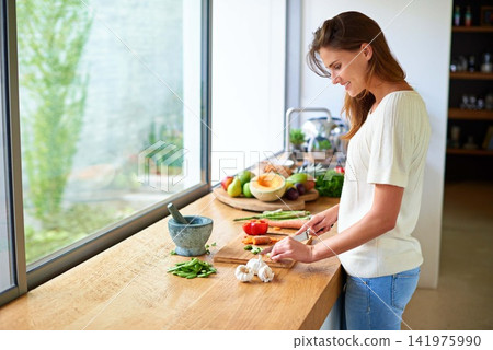 Cooking, home and happy woman with healthy food, meal prep and cutting fresh vegetables for lunch. Diet, wellness and girl at kitchen counter with ingredients, nutrition and dinner in apartment. Cooking, home and happy woman with healthy food, meal prep and cutting fresh vegetables for lunch. Diet, wellness and girl at kitchen counter with ingredients, nutrition and dinner in apartment. 141975990