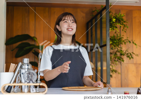 Female staff working at a stylish cafe/bar Female staff working at a stylish cafe/bar 141976016