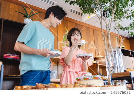 一對夫婦在自助餐檯上挑選食物 141976021