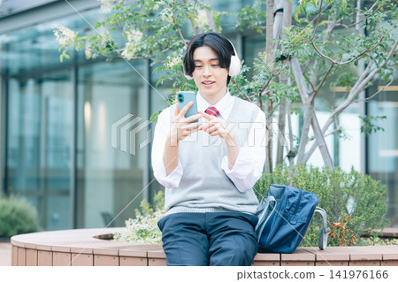 Student: A male student looking at his smartphone. Photo cooperation: Denpa Gakuen Tokyo Electronics College. Student: A male student looking at his smartphone. Photo cooperation: Denpa Gakuen Tokyo Electronics College. 141976166