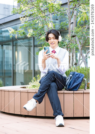 Student: A male student looking at his smartphone. Photo cooperation: Denpa Gakuen Tokyo Electronics College. Student: A male student looking at his smartphone. Photo cooperation: Denpa Gakuen Tokyo Electronics College. 141976169