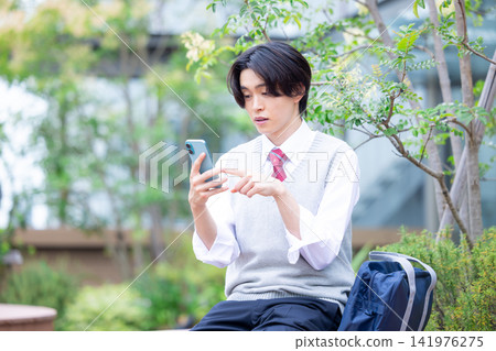 Student: A male student looking at his smartphone. Photo cooperation: Denpa Gakuen Tokyo Electronics College. Student: A male student looking at his smartphone. Photo cooperation: Denpa Gakuen Tokyo Electronics College. 141976275