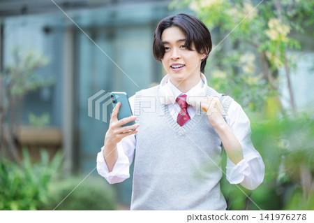 Student: A male student looking at his smartphone. Photo cooperation: Denpa Gakuen Tokyo Electronics College. Student: A male student looking at his smartphone. Photo cooperation: Denpa Gakuen Tokyo Electronics College. 141976278