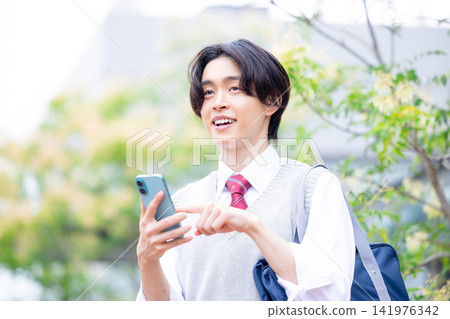 Student: A male student looking at his smartphone. Photo cooperation: Denpa Gakuen Tokyo Electronics College. Student: A male student looking at his smartphone. Photo cooperation: Denpa Gakuen Tokyo Electronics College. 141976342
