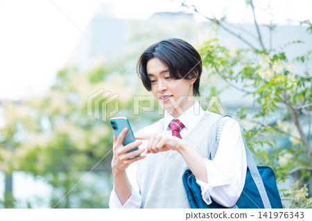 Student: A male student looking at his smartphone. Photo cooperation: Denpa Gakuen Tokyo Electronics College. Student: A male student looking at his smartphone. Photo cooperation: Denpa Gakuen Tokyo Electronics College. 141976343