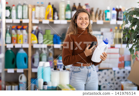 Young woman scanning QR-code on detergent in supermarket Young woman scanning QR-code on detergent in supermarket 141976514