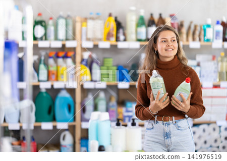 Young woman choosing dishwashing liquid in department store Young woman choosing dishwashing liquid in department store 141976519