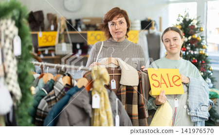 Teen girl with poster in hands announce mega Black Friday discounts, presenting SALE Teen girl with poster in hands announce mega Black Friday discounts, presenting SALE 141976570