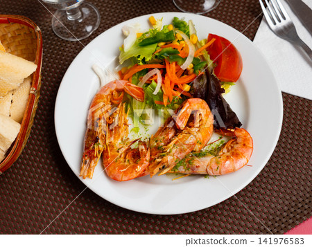 Tasty baked shrimp with lemon and fresh vegetables 141976583