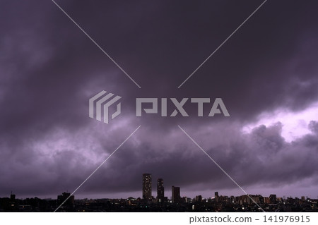 雷雨天氣中雲層內的放電;閃電照亮了城市的夜景。 雷雨天氣中雲層內的放電;閃電照亮了城市的夜景。 141976915