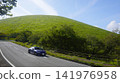 A blue sports car (Toyota) driving on a road near Mt. Omuro (Izu Kogen) in summer. 141976958