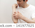 A middle-aged man is scratching his arm raw due to severe itching. Itchy, itchy. 141977025