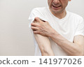 A middle-aged man is scratching his arm raw due to severe itching. Itchy, itchy. 141977026