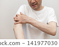 A middle-aged man is scratching his arm raw due to severe itching. Itchy, itchy. 141977030