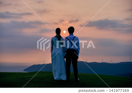 A couple looking at the sunset A couple looking at the sunset 141977169