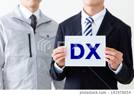 一位身穿西裝的年輕商人，手持 DX 白板；身穿工作服的中年男子。 141978054