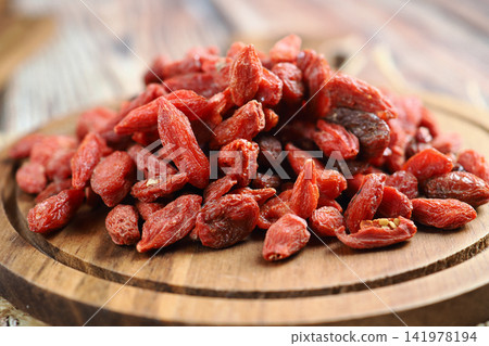 Goji berries on a wooden plate in a kitchen setting Goji berries on a wooden plate in a kitchen setting 141978194