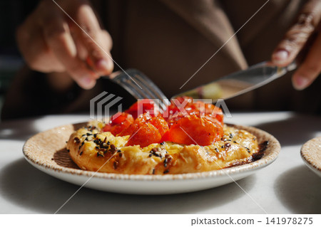 a savory tomato tarte tatin served on a speckled ceramic plate a savory tomato tarte tatin served on a speckled ceramic plate 141978275
